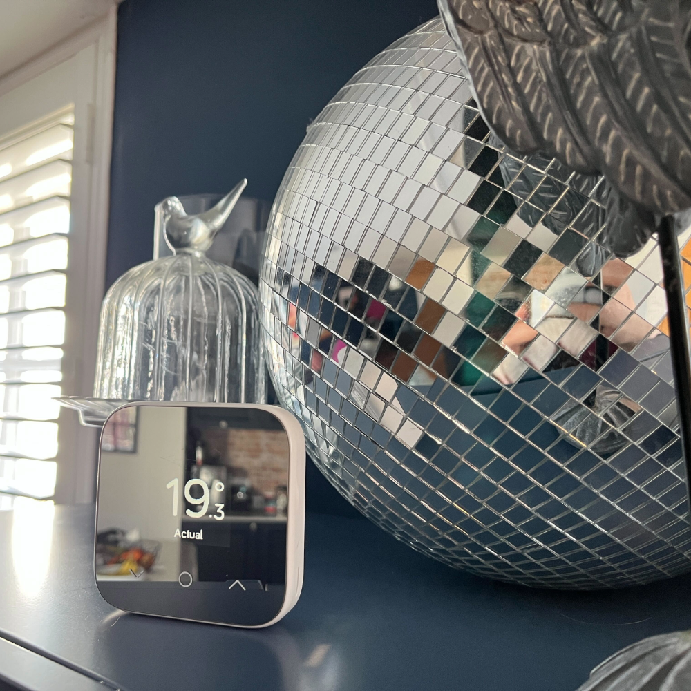 Hive Mini V4 Smart Thermostat next to a disco ball in Sarah's home
