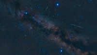 night sky image showing three bright stars forming a triangle, with the milky way glowing between.