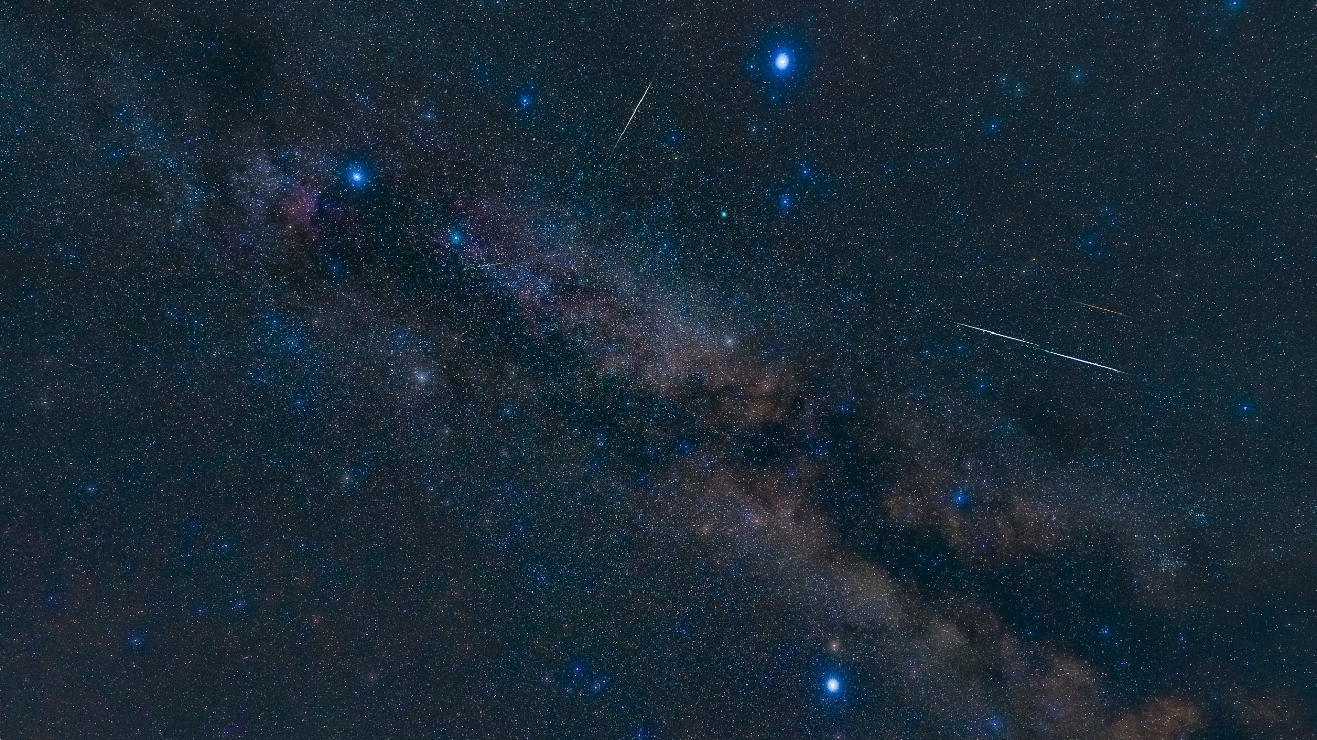 night sky image showing three bright stars forming a triangle, with the milky way glowing between.