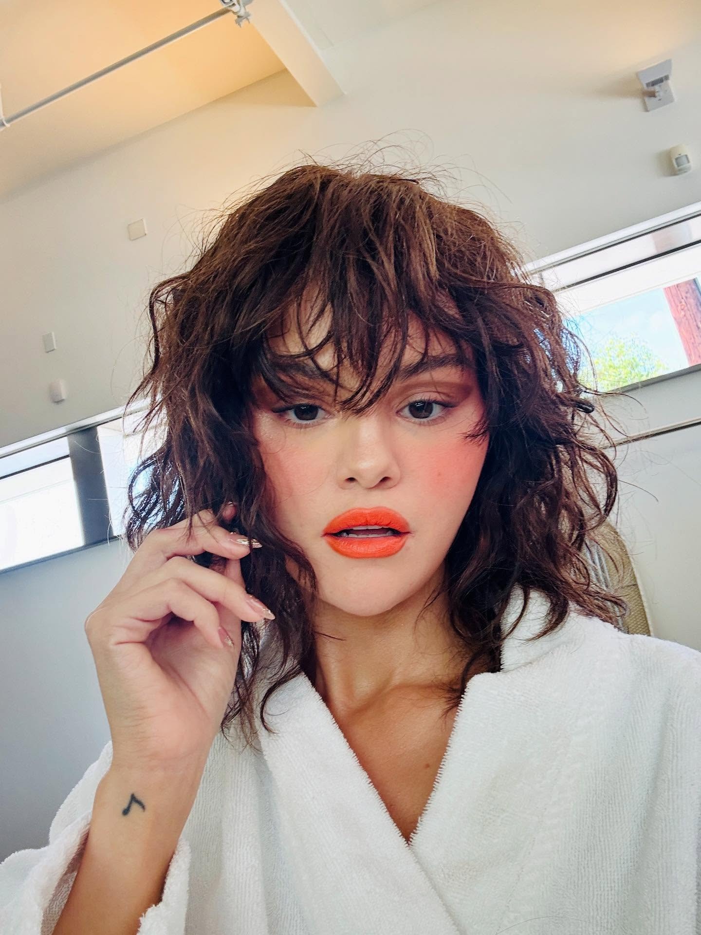 Selena Gomez taking a selfie with a shag hairstyle