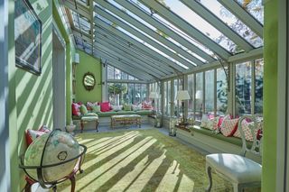 orangery with green walls an scatter cushions