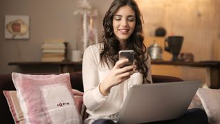 Woman using phone and laptop; best cloud storage services