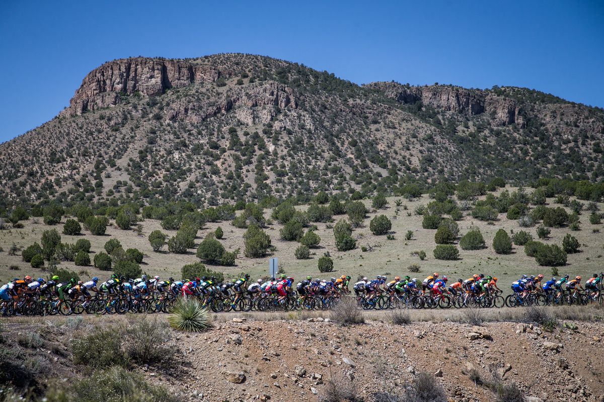 The peloton gets strung out heading towards the feed zone.