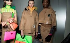 Models wear camel coloured outerwear with bright neon bags