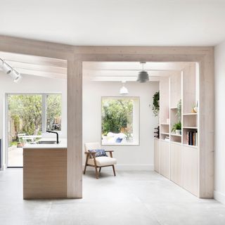 pale timber shelving in a white kitchen living space with a framed surrounding the room