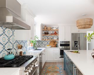 A white kitchen with blue island, and white and blue patterned tiles.