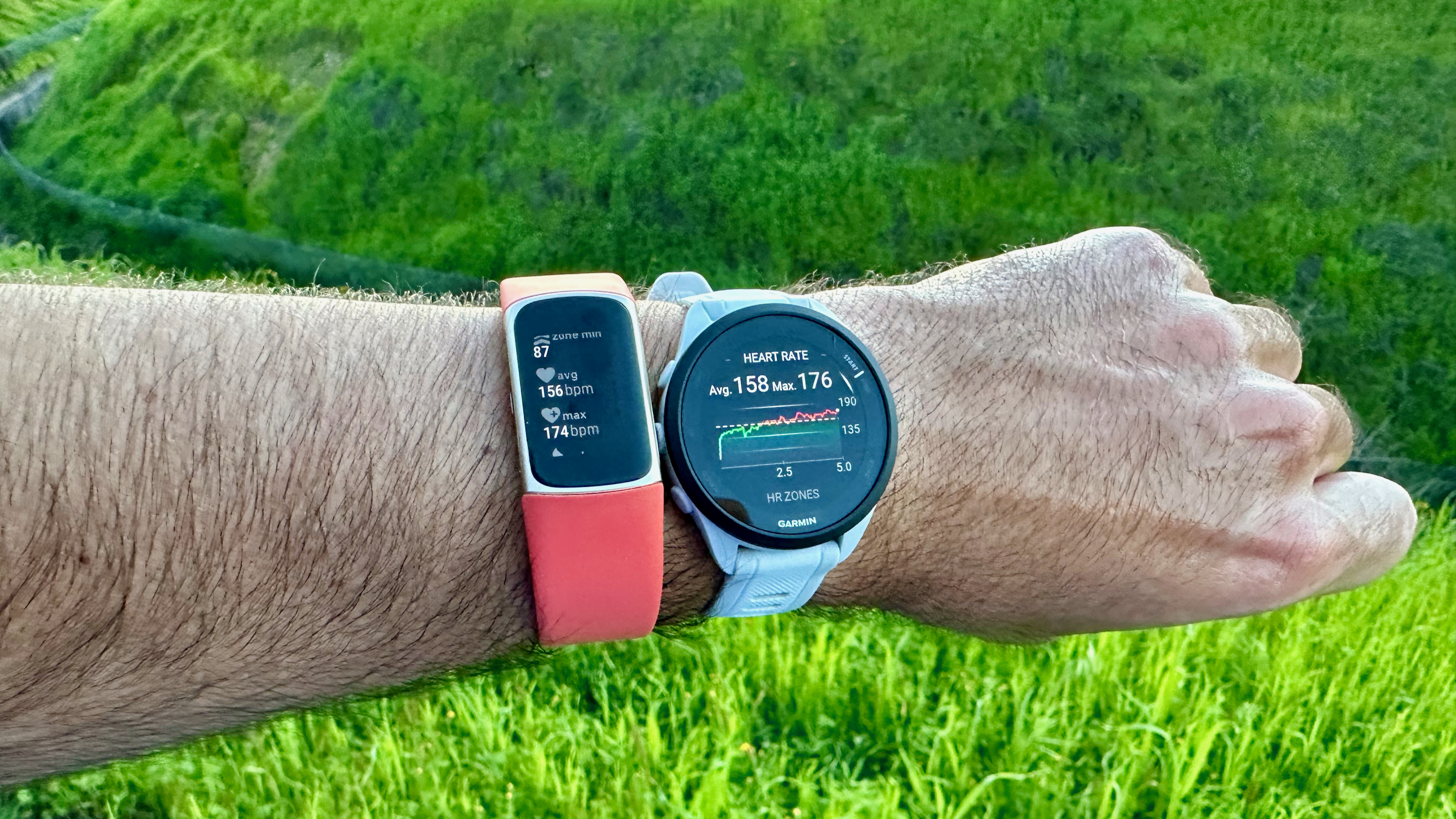 The Garmin Forerunner 165 and Fitbit Charge 6 worn on one wrist, showing a post-run summary.