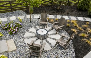 A beautiful rounded firepit with chairs placed around it