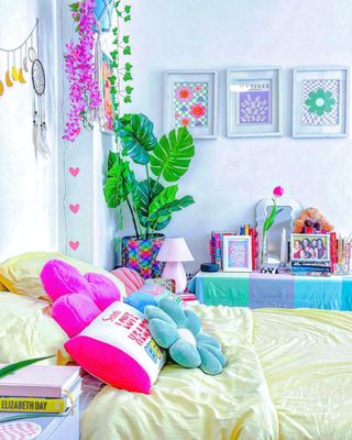 A colorful bedroom with a yellow bed with fun cushions