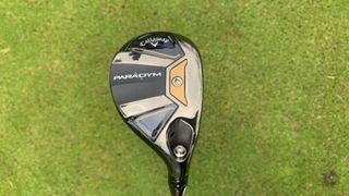 The classy Callaway Paradym Hybrid showing off its very cool clubhead design on a grassy background