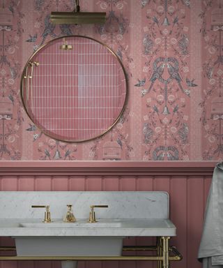 pink panelled wall with pink floral wallpaper above, white sink and gilt framed mirror