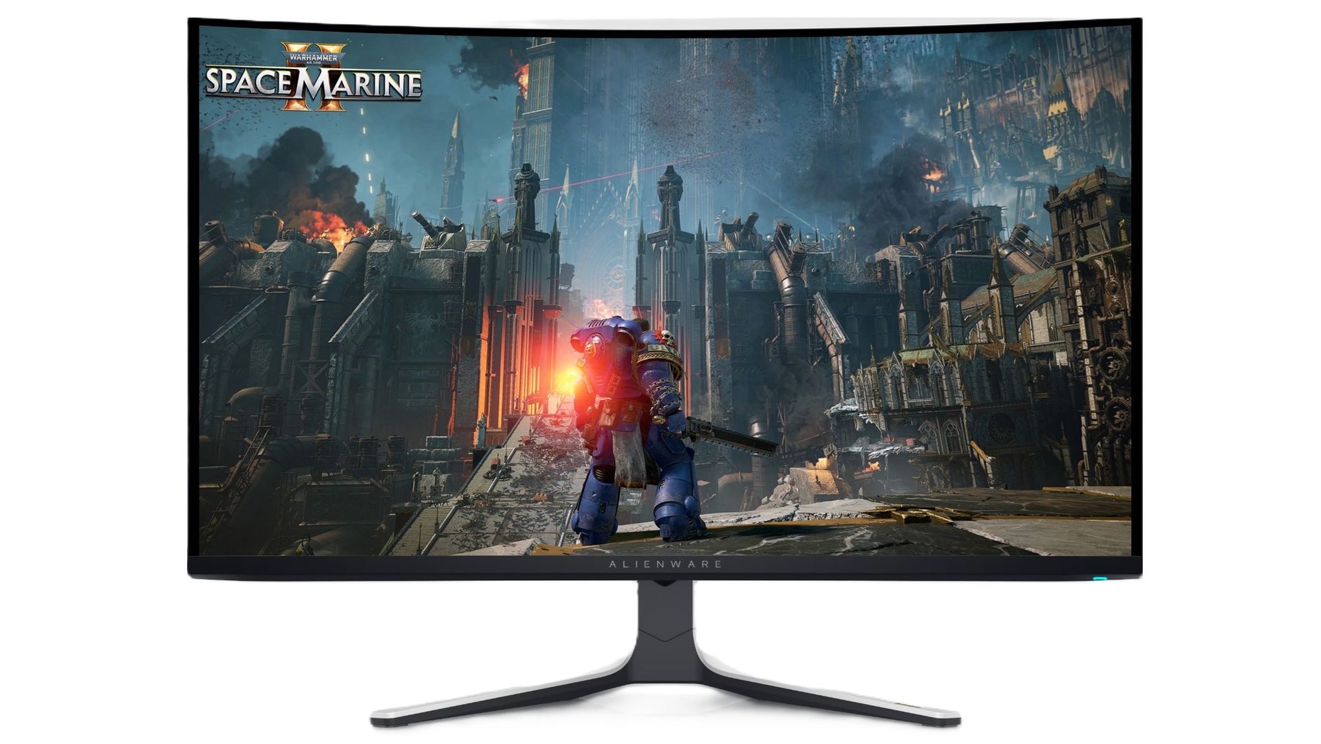 A curved Alienware monitor displays Space Marine in a ruined, smoke-filled city, with an armored warrior facing fires and towering debris. The scene feels intense and war-torn.
