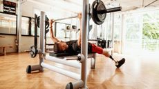 Person doing bench press in gym
