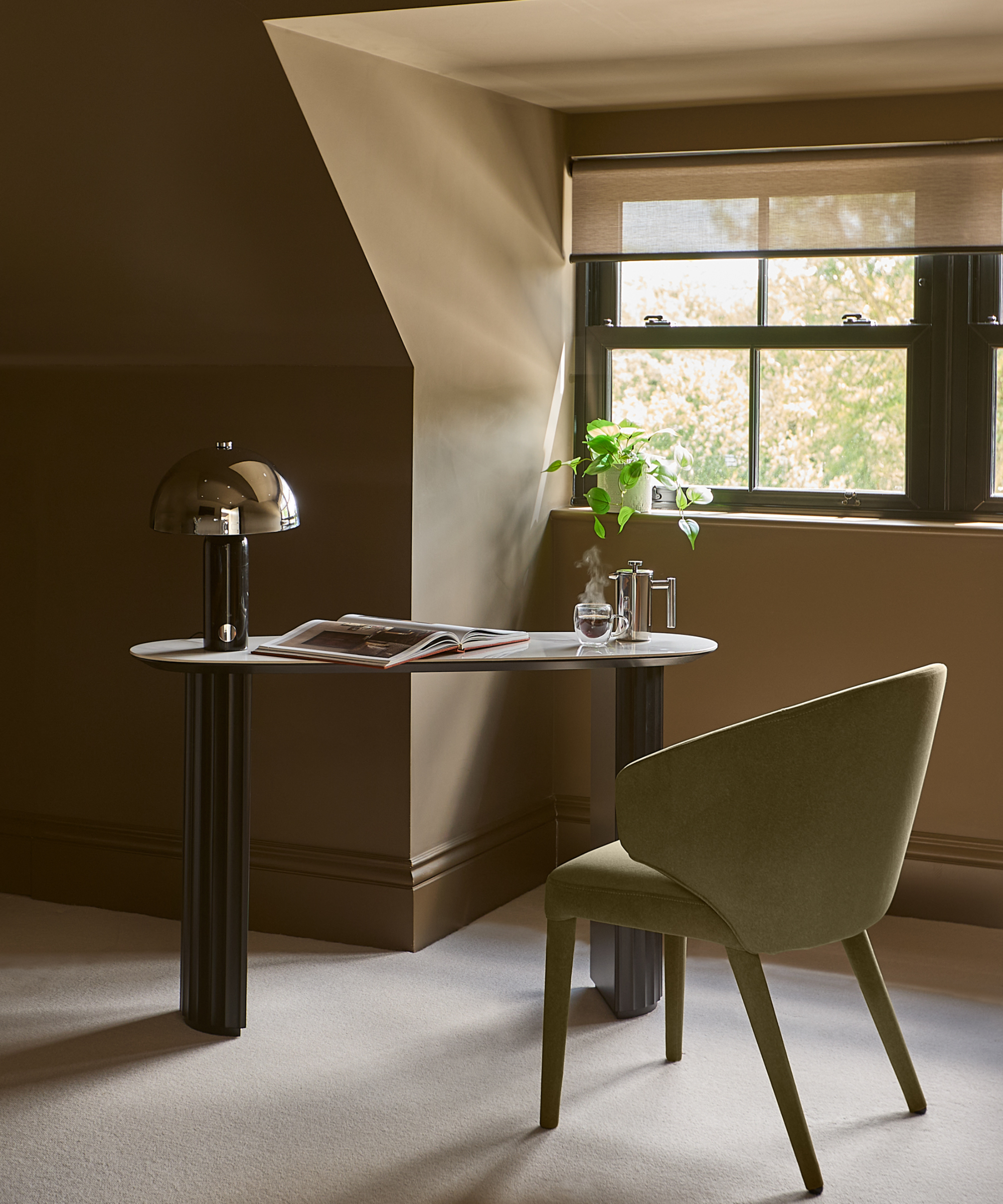 loft conversion bedroom with table, chair and lamp in dormer window area