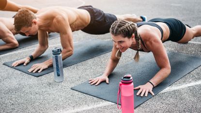 Man and woman both completing a plank exercise