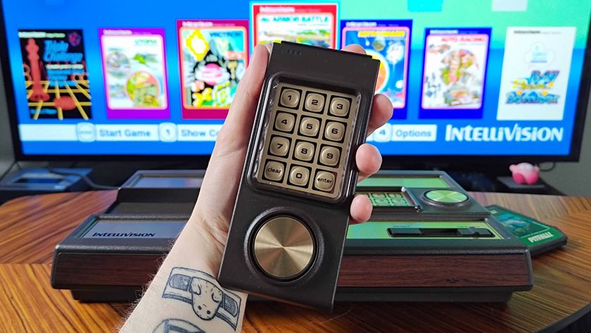 Hand holding Intellivision Sprint controller with console behind and TV displaying main menu in backdrop.