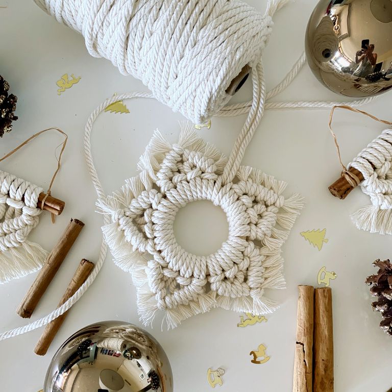 DIY christmas decorations made of macrame on a table with cinnamon sticks and pine cones