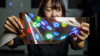 Una mujer usando la nueva pantalla flexible de LG Display