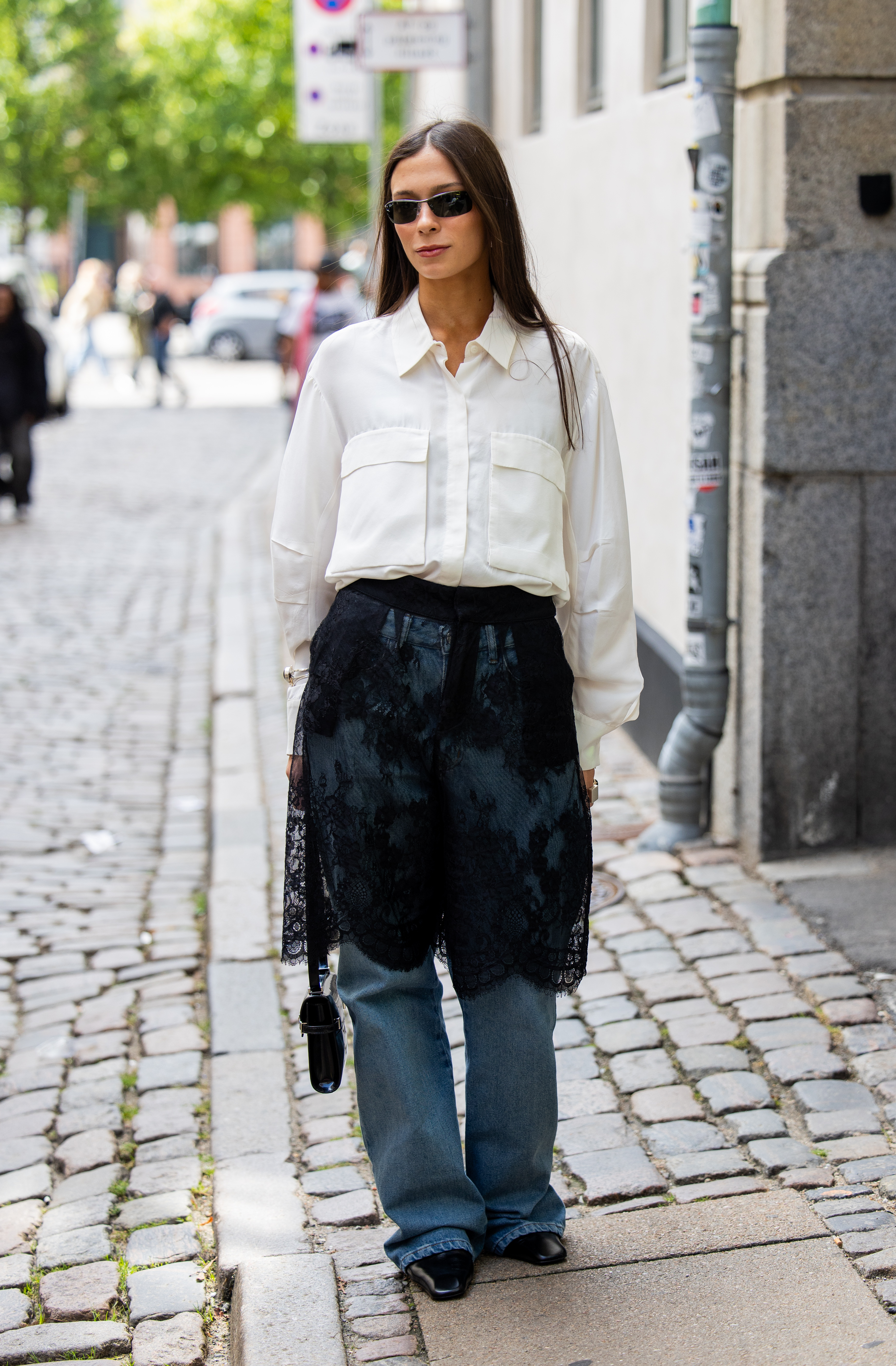 Photo of Scandi woman wearing sheer black lace skirt over jeans during Copenhagen Fashion Week.