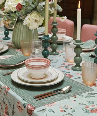 Blue place mats, pink and white bowl, green candle holders