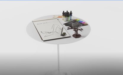 A drawing pad, inks and pens on a round white table