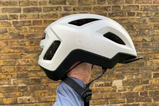 Male cyclist holding the Bollé Halo React MIPS helmet which is one of the best commuter bike helmets