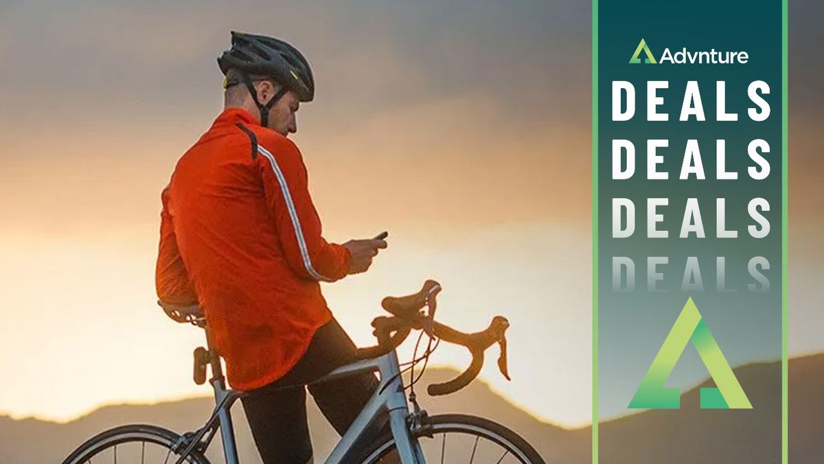 Man standing beside bike at sunset using Garmin Edge 830 bike computer