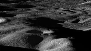 a grey and black shadowed surface covered in craters