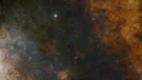 A view of a starry section of space. One bright spot exists in the top left.