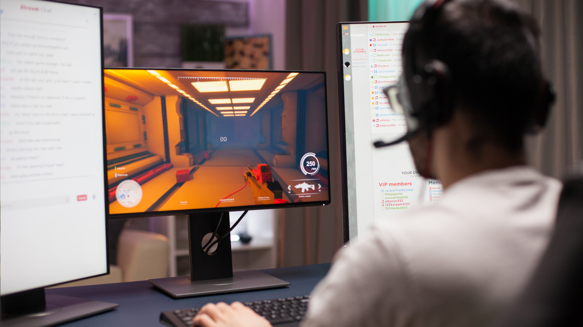 Young man playing shooter competitive game in a dark room wearing headphones