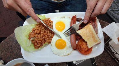 CAPE TOWN, SOUTH AFRICA - JUNE 17:An England fan eats an full English breakfast on June 17, 2010 in Cape Town, South Africa. Cape Town hosts the match between England and Algeria in the secon