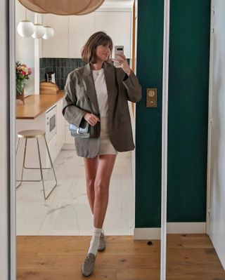 French woman wearing miniskirt, blazer, and loafers