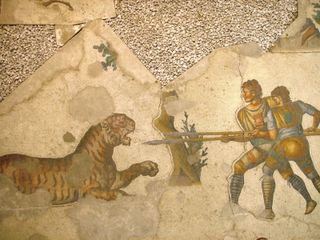 Mosaic painting of two people pointing spears at a tiger.