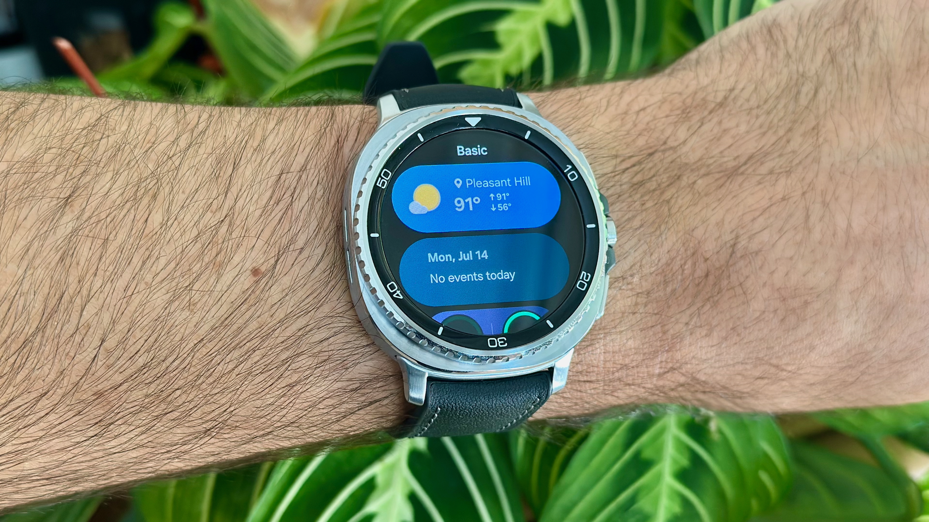 The "Basic" Tile on the Samsung Galaxy Watch 8 Classic showing Weather, Calendar, and part of the Battery widget