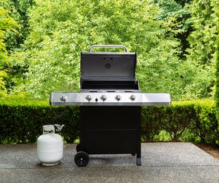 large gas grill and gas canister on a patio