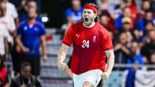 Mikkel Hansen of Denmark celebrates during the Men's Preliminary Round Group B, dressed all in red, at the 2024 Paris Olympic Games.