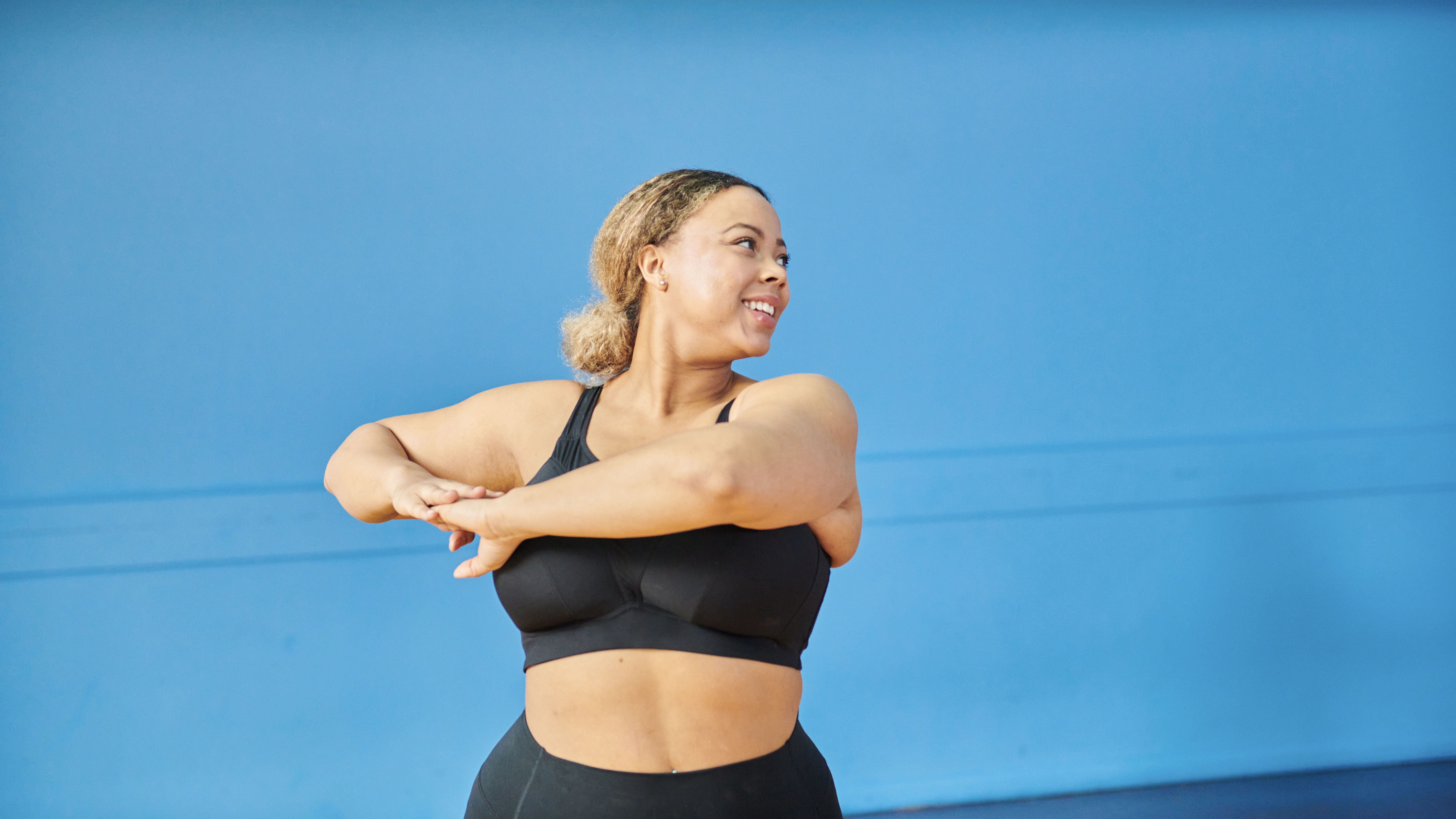 Woman stretching on blue background