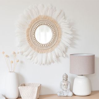 room with white wall and fringed mirror on wall