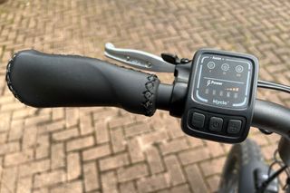 The Mycle grips and power control unit is on the left hand side of the handlebars, as show in this close up image, with a brick drive in the background.