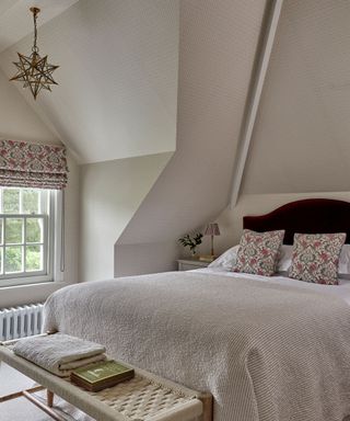 Loft bedroom with wallpapered sloped ceilings