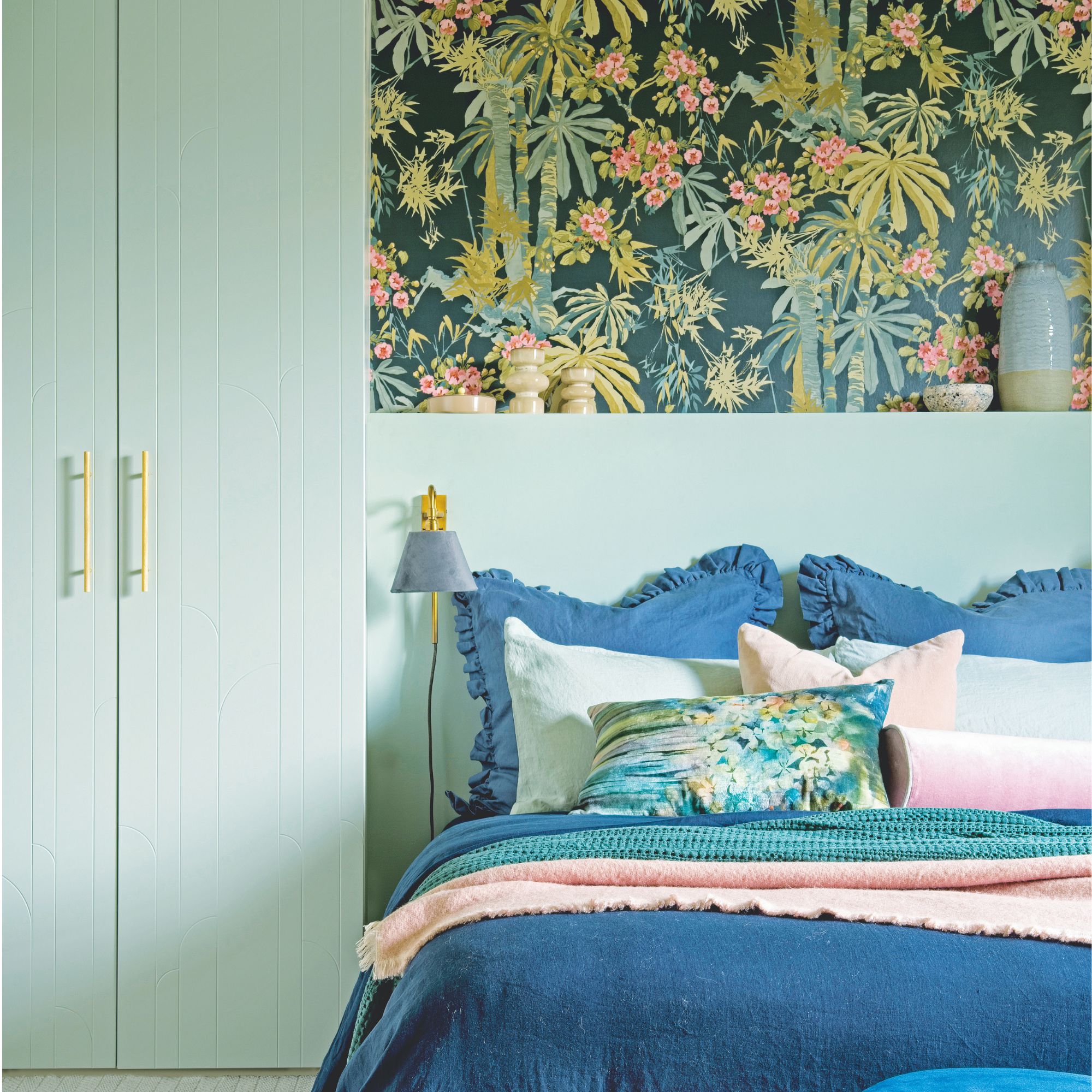 A blue bedroom scheme with pink accents and botanical wallpaper