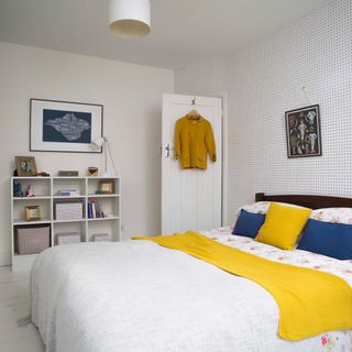 bedroom with white wall frames on wall and white bed