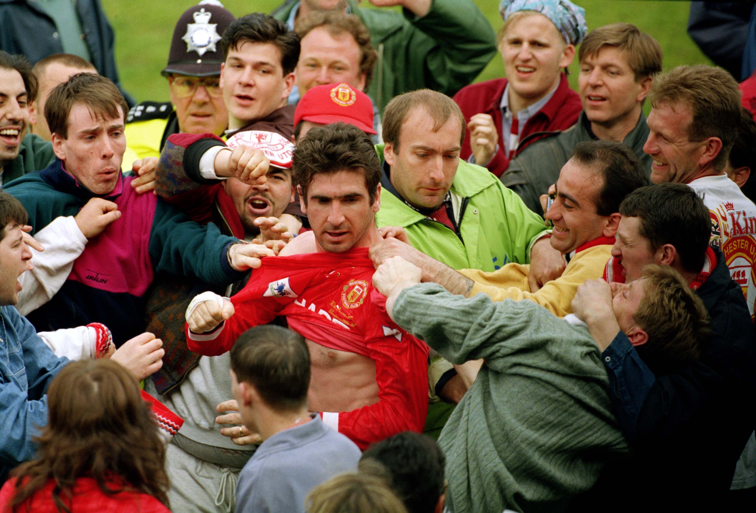 Eric Cantona is mobbed by Manchester United fans after the club's Premier League title win in May 1993.