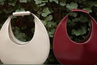 Two Staud Moon bags against green leaf background.