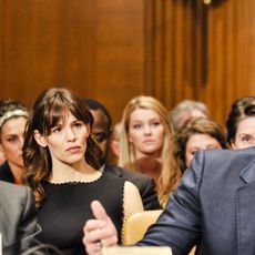 Woman in the crowd looks on at proceedings in a court