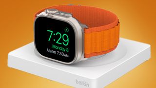 An Apple Watch charging on the Belkin BoostCharge Pro on an orange background