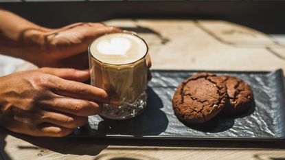 How to make coffee taste better coffee being put on a slate with chocolate cookies beside it