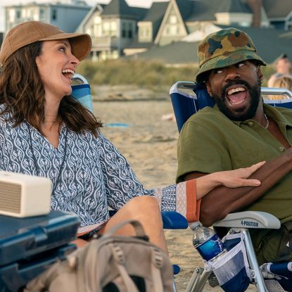 Tina Fey as Kate and Colman Domingo as Danny, laughing while sitting on the beach, in Episode 203 of The Four Seasons, Season 2.