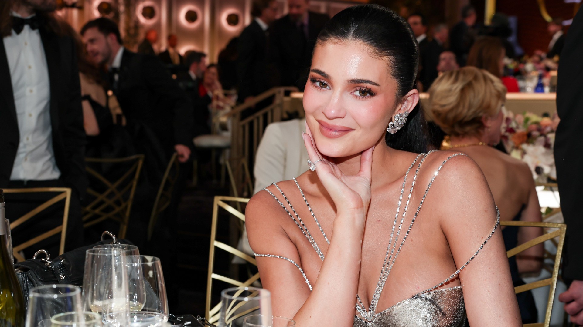a white woman with dark hair photographed sitting at a table during an awards ceremony
