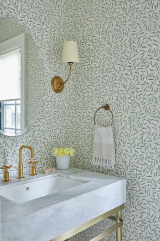 powder room with green patterned wallpaper marble sink